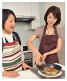 タレを回しかける蓑田とほりえ先生の写真。