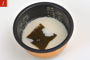 １　だし昆布の入った釜の写真。