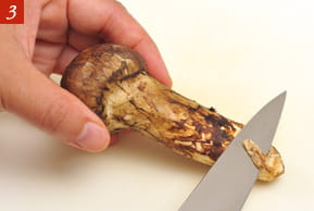 ３　マツタケの石づきを切っている写真。