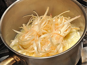 束ねたアスパラを蒸し炒めする写真。