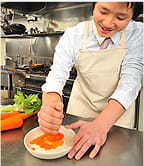 ニンジンをすりおろす河原林の写真。