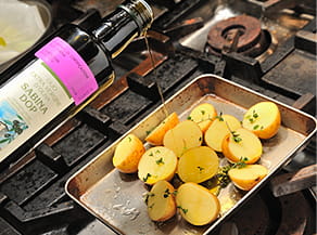 オリーブオイルを新じゃがいもにかける写真。