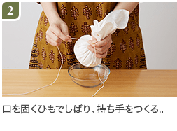 2.口を固くひもでしばり、持ち手をつくる。