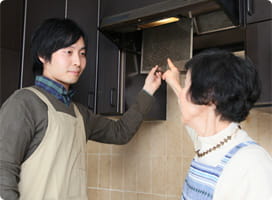 換気扇のネットを外す依藤と前さん。