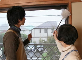 ポリばたきを手に説明する前さんと依藤。