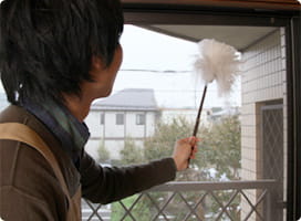 ポリばたきで掃除する依藤。