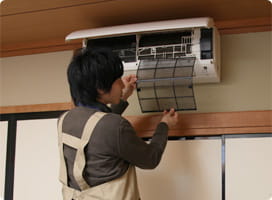 エアコンのフィルターを外す依藤。