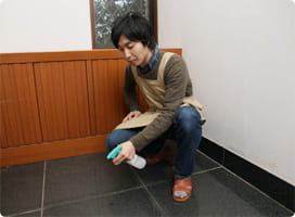 床に洗剤水をスプレーする依藤。