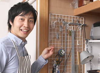 壁収納を指さす依藤